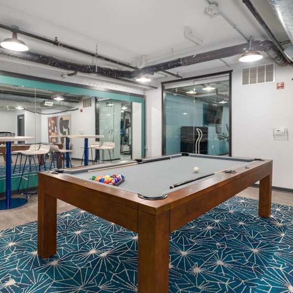 A pool table in a room with a blue carpet.