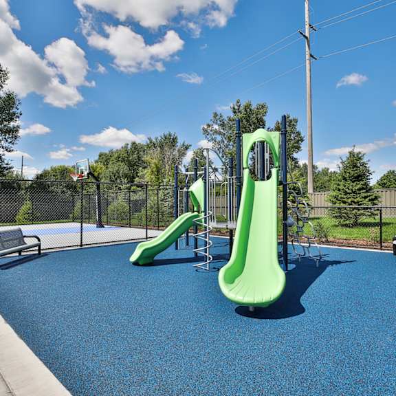 A playground with a blue surface and a green slide.