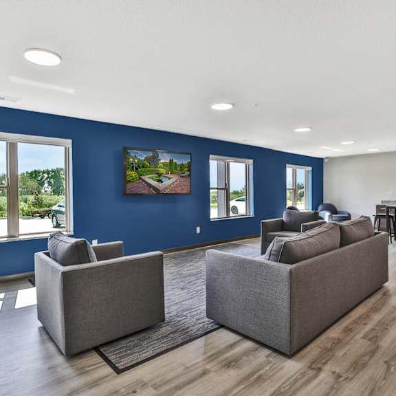 A living room with two grey couches and a wooden floor.
