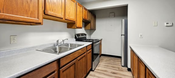 a kitchen with wooden cabinets and a sink and a refrigerator