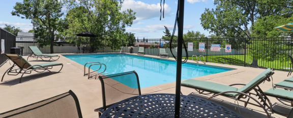 a swimming pool in front of a building with a fence