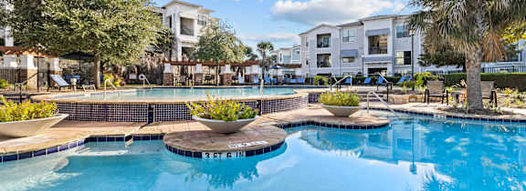 A large house with a pool in front.