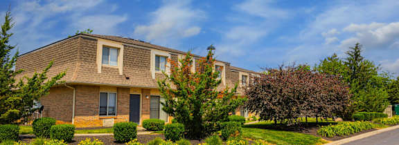 A house with a driveway and landscaping in front.