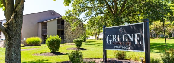 a sign that says greene apartments with a building in the background