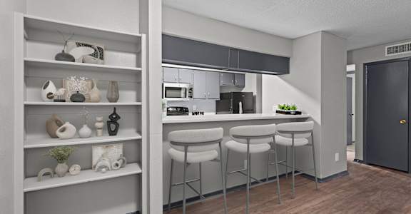 A kitchen with a bar stool and a shelf with decorative items.