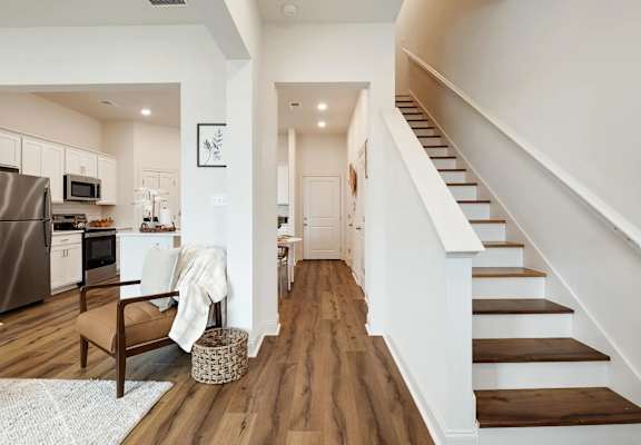 A modern kitchen with a staircase leading to the upper floor.