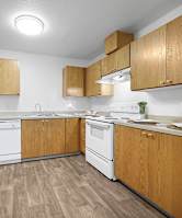 A kitchen with wooden cabinets and white appliances.