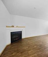 A room with a fireplace and wood flooring.
