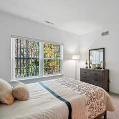 A bedroom with a large bed and a painting on the wall.