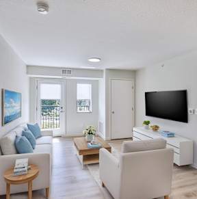 A living room with a television, couch, and a coffee table.