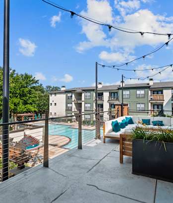 A patio with a pool and a table with chairs.