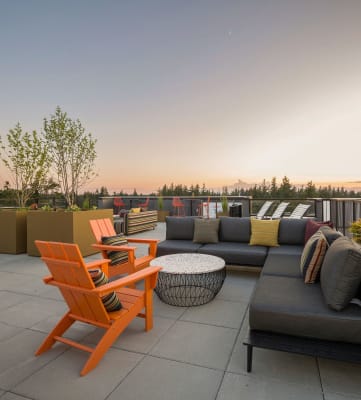 a roof deck with couches chairs and a coffee table