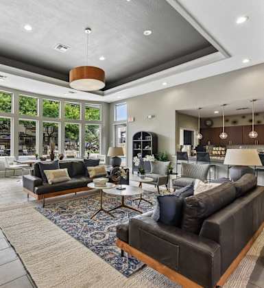 A modern living room with a stone fireplace and a large window.