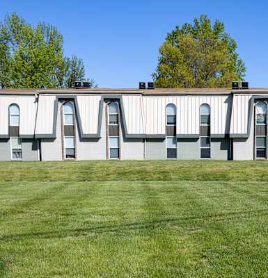 a building with many windows and a grassy area in front of it