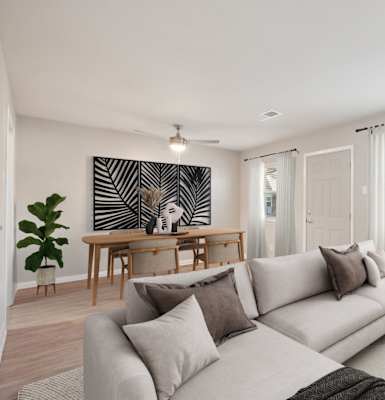 A living room with a grey sofa, a wooden table, and a large painting on the wall.