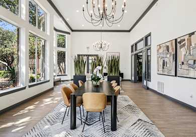 A dining room with a table set for six with chairs around it.