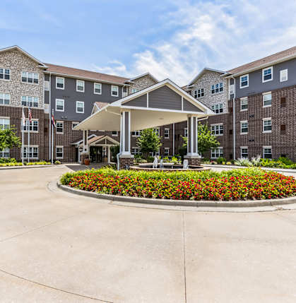 A large building with a flower bed in front.