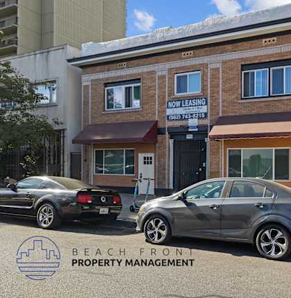 the front of the beach front property management office with cars parked outside