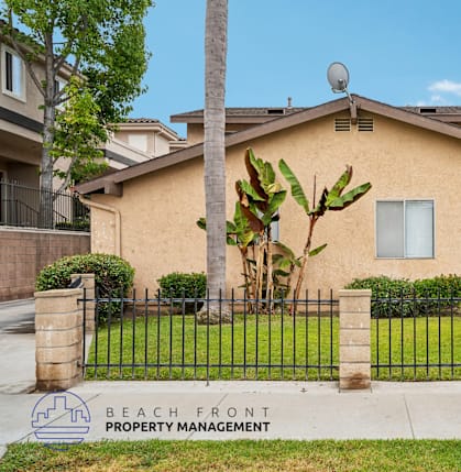 A house with a sign that says "Beach Front Property Management".