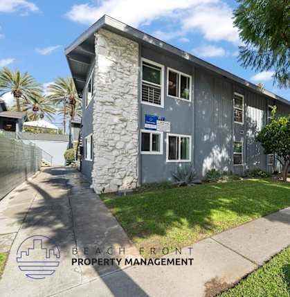 A building with a stone pillar and a sign that says "BEACH FRONT PROPERTY MANAGEMENT".