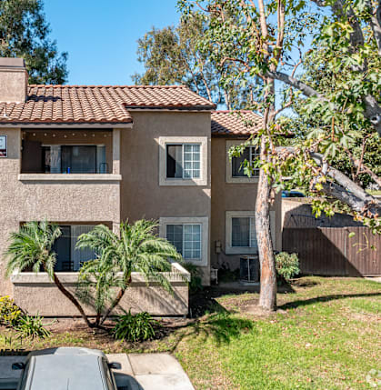 A house with a brown roof and a car parked in front.