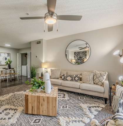 A living room with a white couch, a wooden coffee table, and a rug with a geometric pattern.