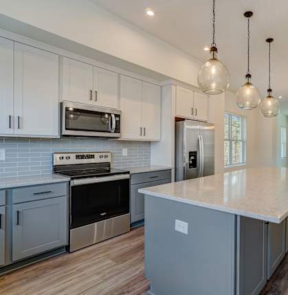 a kitchen with white cabinets and stainless steel appliances and a geometric design