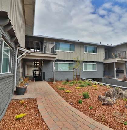 exterior view of apartments with a landscaped yard and walkway