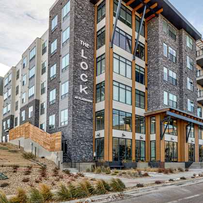 The Lock apartment building is a modern structure with a mix of stone and wood accents.