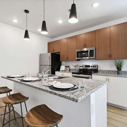 a kitchen with a granite counter top and a bar with stools