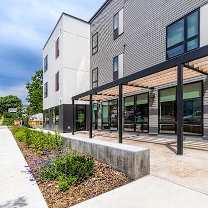 a building with a patio and a sidewalk in front of it