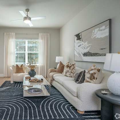 A living room with a couch, coffee table, and a painting on the wall.
