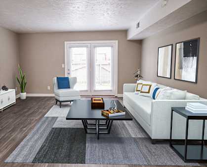 A living room with a white sofa, a coffee table, and a television.