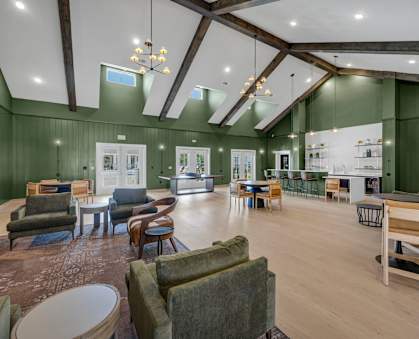 A spacious living room with a variety of seating options and a fireplace.
