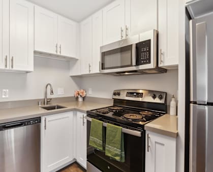 A kitchen with white cabinets and a black stove top.