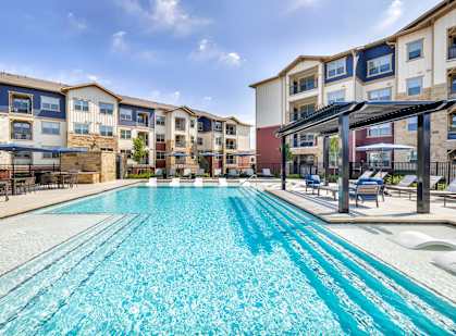 a swimming pool with an apartment building in the background