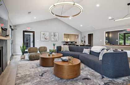 A modern living room with a grey sofa, a wooden coffee table, and a grey rug.