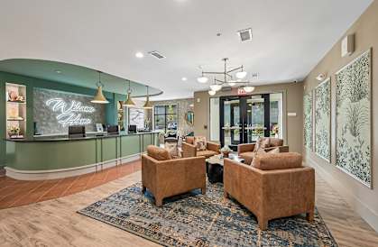 A reception area with a green wall and a sign that says "Welcome".