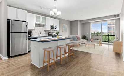 A kitchen with a refrigerator, stove, and bar stools.