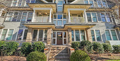 A large, two-story house with a front porch and multiple windows.