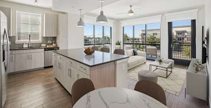 A modern kitchen with a large island and a view of the city.