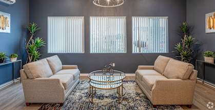 a living room with couches and a glass coffee table