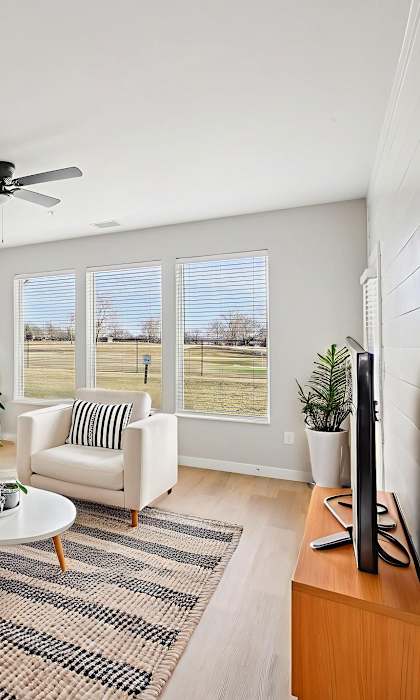 A living room with a white couch, a coffee table, and a flat screen TV.