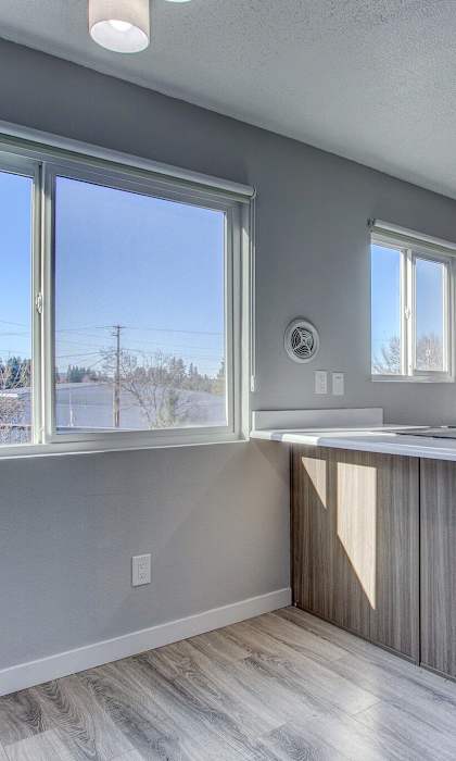 A kitchen with a refrigerator, sink, and cabinets at Tigardville Apartments, Tigard