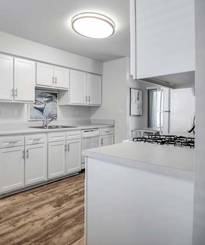 A modern kitchen with white cabinets and a marble table. at Estates at Palm Bay, Fort Walton Beach, FL, 32547