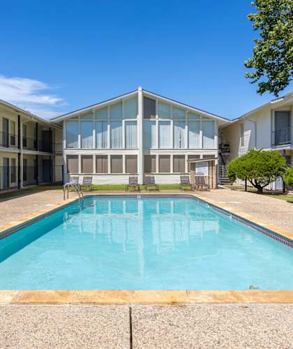 A swimming pool in a courtyard surrounded by buildings.