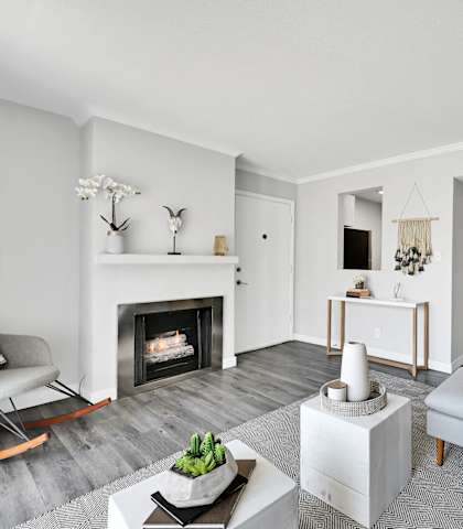 A modern living room with a fireplace and a grey sofa.