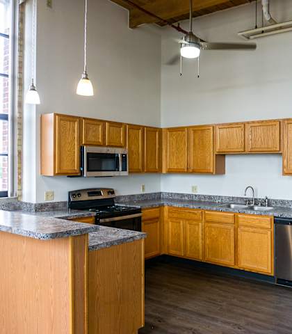 an empty kitchen with wooden cabinets and stainless steel appliances