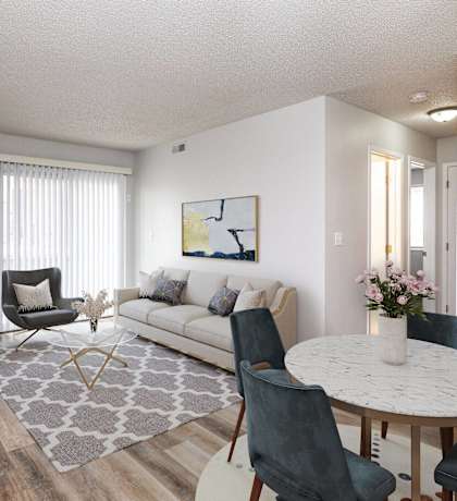 A living room with a white couch, a grey rug, and a round table with chairs.at Fish Creek, Norwalk, IA