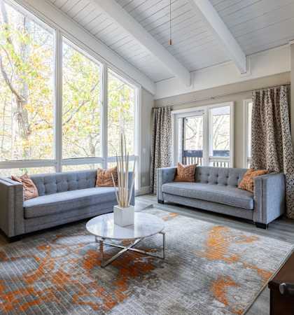 two couches and a table in a living room with large windows at Tucker Square, Georgia